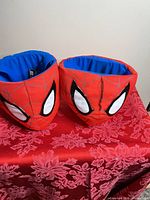 Two Spider-Man plush baskets on red surface