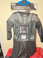 Full front view of Darth Vader child costume on hanger with packaging