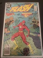 Front cover of DC Comics Flash issue #21 with Flash character and monsters in background