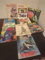 Full view of all 9 comic size books showing various titles and covers.