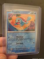 Front side of Squirtle Pokémon card in top loader showing artwork and card details.