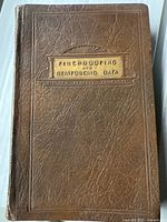 Front cover of the 1926 book titled 'Fireproofing and Reinforcing Data' embossed on a textured brown faux leather cover with a decorative plaque and title in gold.
