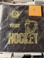 Front view of the sealed 1992 O-Pee-Chee Premier hockey binder with gold foil design and plastic seal showing age-related cloudiness.