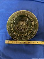 Top view of green glazed ceramic ashtray with embossed 'E. Provost Monuments, Sherbrooke, Que. TEL: LO 9-1700' and central 'Rock of Ages' label