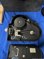 Top inside view of the camera showing film spool and mechanical components, camera back open with label.