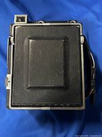 Top view of the camera showing the folded leather front and metal frame with side handle