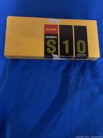 Image of the Kodak Instamatic S10 camera original yellow box showing some wear.
