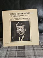 Front cover of vinyl album, showing title 'That Was The Week That Was' and a black and white photo of John F. Kennedy.