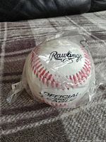 Front view of the Rawlings official league baseball in original plastic packaging showing brand and 'Official League' text.