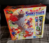 Front view of sealed Super Mario Blow Up Shaky Tower box showing characters and game components illustration.