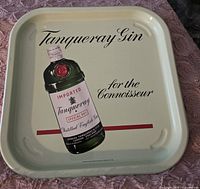 Front of the metal tray showing Tanqueray Gin bottle and text "Tanqueray Gin for the Connoisseur" on a pale cream background.