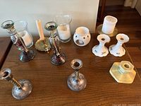Front view of various candle holders arranged on wooden table