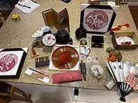 Photo showing large assortment of Asian collectible items including framed art, fans, pottery, wood carvings.