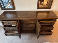 Front view of the wood dresser with all drawers and cabinet doors partially open.