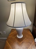 First photo showing one of the white ceramic table lamps with off shade, highlighting the lamp base and shade shape