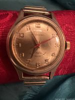 Front view of Rodasonic watch with scratched dial, silver-tone case, and red second hand.