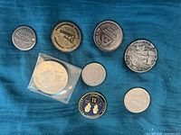 Top view of all tokens and coins laid out on blue fabric, showing all items in the lot