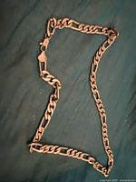 Full view of the men's silver chain necklace laid out flat showing its length and style.