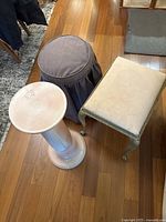 Photo showing all three items: ceramic plant stand, round fabric stool, rectangular cushioned stool.