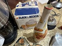 Boxed Black & Decker citrus juicer with a ceramic utensil holder in front