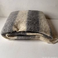 Folded throw showing color stripes in cream and dark gray.