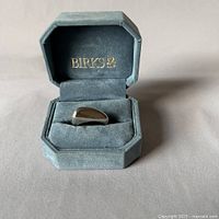 Front view of the BIRKS sterling silver pebble ring in the BIRKS velvet ring box, box lid open showing gold BIRKS logo.