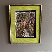 Framed oil painting hanging on a wall, showing full framed artwork with green mat and gold outer frame