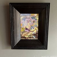 Frontal photo showing the entire framed abstract oil painting hung on a wall, highlighting the frame and visible signature.