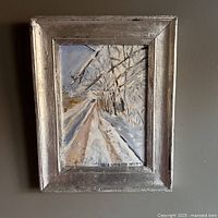 Frontal image of the original winter oil painting with silver leaf style frame hanging on a wall.