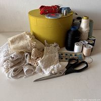 Full lot photo showing Finny scissors, lace trims, spools of thread, British Snap package, tape measure, thimble and yellow oval box.