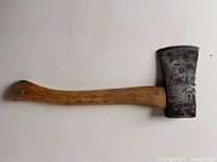 Full side view of axe showing head and wooden handle