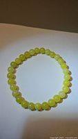 Top down view of the lemon jade bead bracelet showing circular arrangement and variation in bead color.