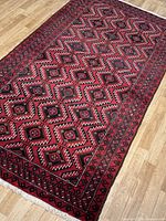 Full view of rug laid on wood floor showing central field and borders