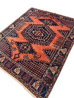 Full view of the rug laid flat showing overall coral field and navy central medallion with border