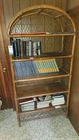 Front view of bamboo book shelf showing five shelves, some books on shelves (contents not included).