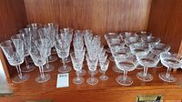Overview of all crystal glasses arranged on wooden shelf