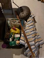 Patio umbrella parts and gardening supplies container with several bags and tools.