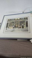 Framed and matted Trisha Romance print "The Window Shoppers" showing the whole artwork with a street scene.