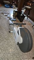 Full side view of the Tunturi R701 air rower showing the seat, rail, and large circular air resistance housing.