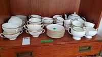 Top shelf showing double-handled soup bowls, teacups, teapot, sugar bowl, creamer and bowls