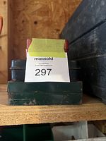 Three stacked metal cases containing the ratchet sets, visible wear on cases.