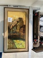 Framed cityscape oil painting shown from above with measuring rulers for scale