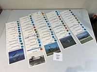 Full view of the laid out collector cards on table showing over 60 aviation-related cards including helicopters and jets.