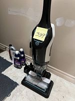 BISSELL CrossWave Cordless Max vacuum upright with sticky note showing lot number 339, positioned on a tiled floor with cleaning liquids in the background.