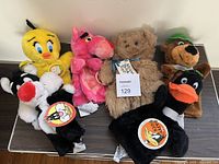 Scene showing all six hand puppets together: Tweety Bird, Pink Panther, Brown Bear, Dog with green hat, Sylvester, and Daffy Duck. Each puppet has tags attached and appears clean and in great condition.