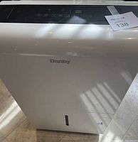 Front view of white Danby dehumidifier with water level window and brand logo visible