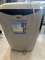 front view of white portable air conditioner showing grille, Premiere badge and front label listing functions