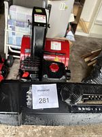 Front of snow blower showing control panel on handle and chute adjustment lever