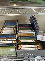 Photo showing a wide angle view of several boxes containing multiple DVD cases and books from The Great Courses series, arranged on shelves.