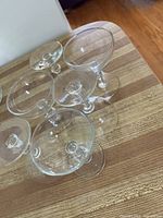 Top view of six clear vintage Libbey Georgian coupe glasses grouped closely on a wood surface.